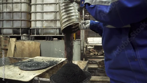 Factory worker pouring carbon black into container. Stock clip