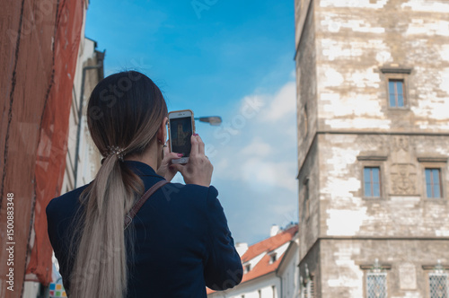 young woman with backpack taking selfie in the old town of Prague, Czech Republic