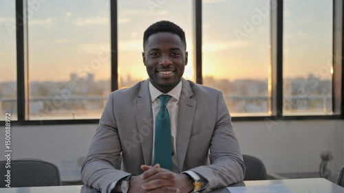 Confident businessman smiling during office sunset meeting