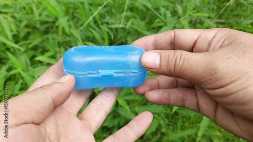 Hands Holding Open Blue Orthodontic Retainer Case