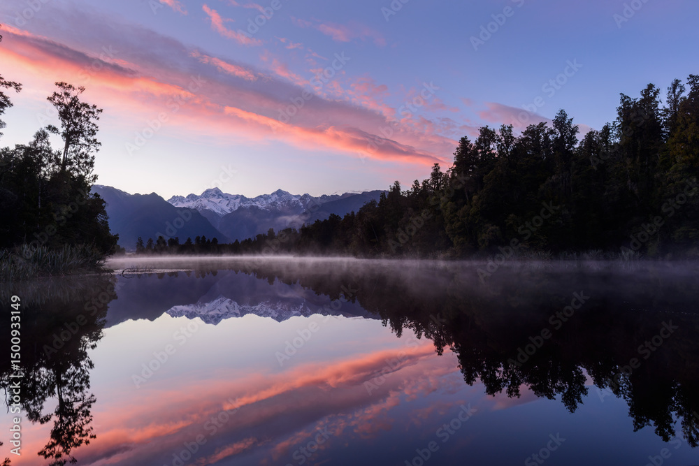 Fototapeta premium Mt Tasman and Mt Cook reflected in the clear waters of Lake Matheson at Sunrise. West Coast. South Island. New Zealand.