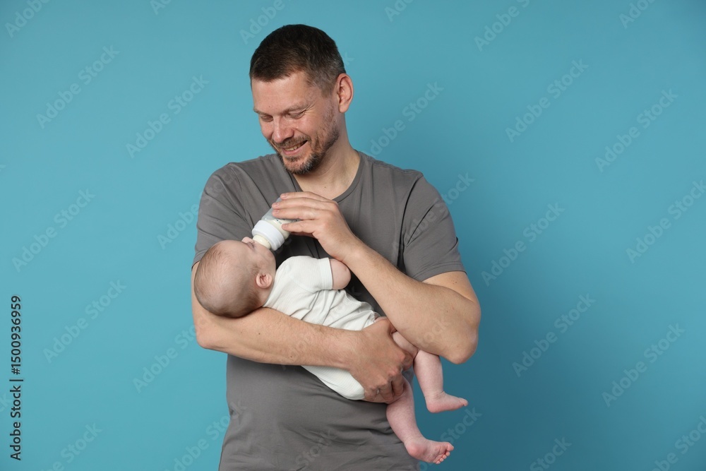 Fototapeta premium Father feeding his little baby with bottle on light blue background