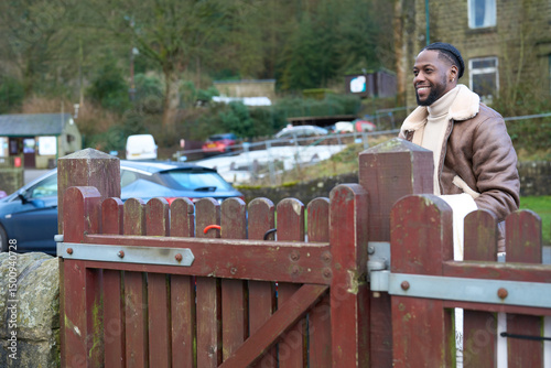 Smiling man at rustic wooden fence photo