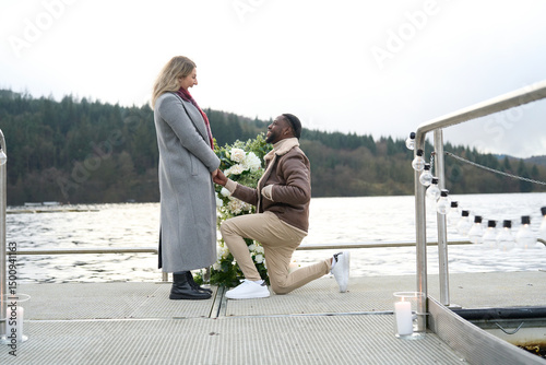 Valokuvatapetti Smiling man proposing marriage to woman on bridge