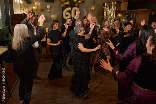People attending dance show at 60th birthday party at nightclub