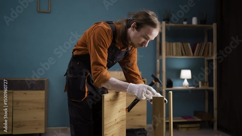 Craftsman using hammer and wooden dowel for assembly furniture