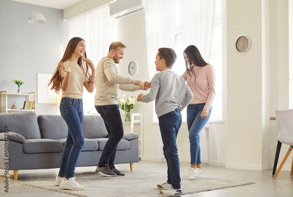 Fototapeta premium Family with children at home enjoys lively dance party, filling space with laughter and energy. Parents with their daughter and son are having fun and fooling around spending time together on weekend.