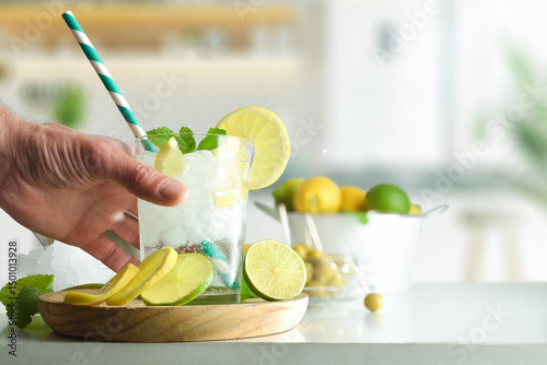 Fotografía Person drinking soda drink with lime and lemon on kitchen