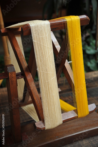 Traditional wheel spinning yarn for separating silk thread from cocoons.