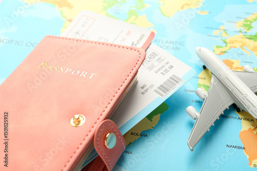 Passport with tickets and plane model on world map, closeup