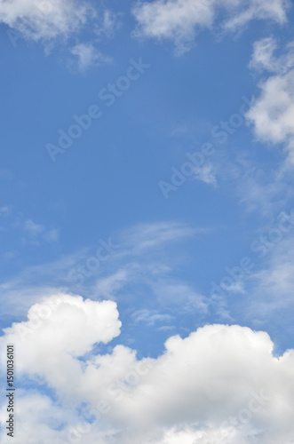 Vertical bright blue sky landscape with white fluffy clouds below . Nature landscape,  environment, beautiful sky background in sunny day.