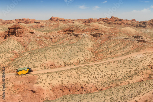 SUV car moving on dusty road at Pingshan Hu Grand Canyon in summer, Zhangye City, Gansu Province in China