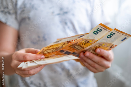 Fototapeta Naklejka Na Ścianę i Meble -  child counting euros, euro banknotes money in fan, euro money, rejoices in success, anticipates what to spend it on, encouraging good financial behavior, economic awareness, money management
