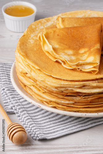 Traditional Russian pancakes with honey on a white wooden table. Homemade russian thin pancakes blini. Russian food, russian kitchen