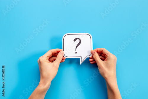Hands are holding Question mark speech bubbles top view. FAQ concept