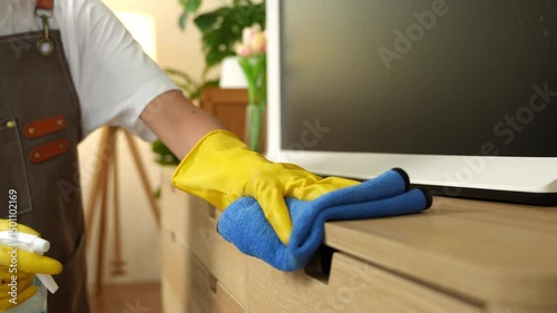 Young female housekeeper cleaning And wipe down the table with a microfiber cloth in the living room. young woman doing housework Housekeeping concept