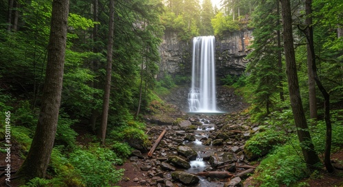 Photo Of A Majestic Waterfall Flowing Through A Dense Green Forest With Sunlight