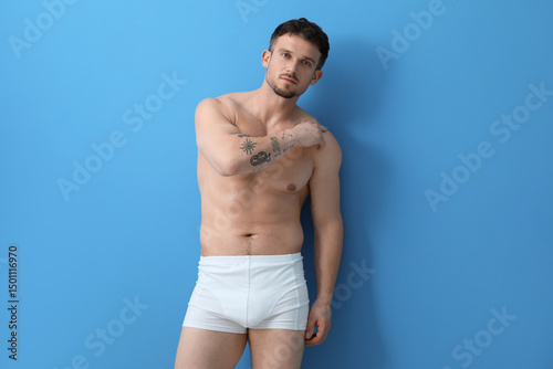 Tableau sur toile Young man in stylish white underwear on light blue background