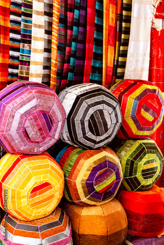 Colorful Moroccan poufs and fabrics with bright ethnic patterns at the oriental market in Marrakech. Travel to Morocco.Vertical.