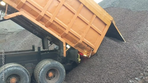 dump truck is unloading sand in the stock pile area. Big dump truck unloading gravel on industrial quarry. close up