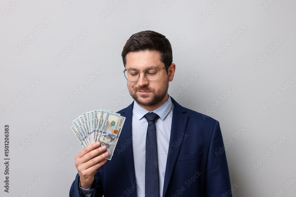 Greedy banker with dollar banknotes on grey background Greedy banker with dollar banknotes on grey background