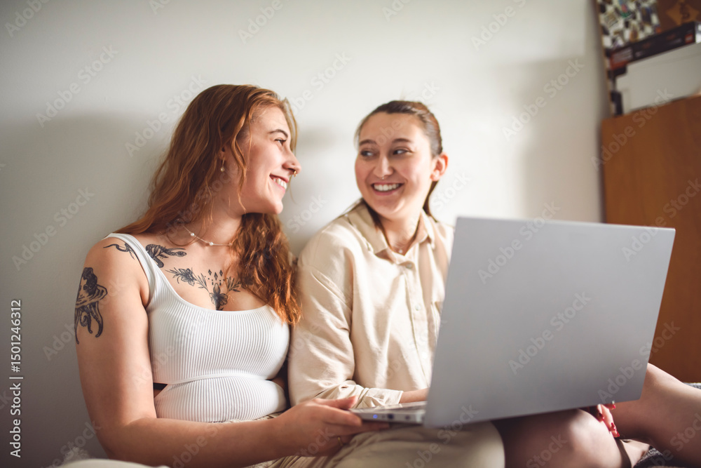 Fototapeta premium nice tattoo young girl sit on bed at home with laptop
