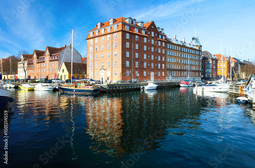 Fototapeta Naklejka Na Ścianę i Meble -  River canal with many boats and ships with small old houses in the neighbourhood area Christianshavn in Copenhagen, Denmark
