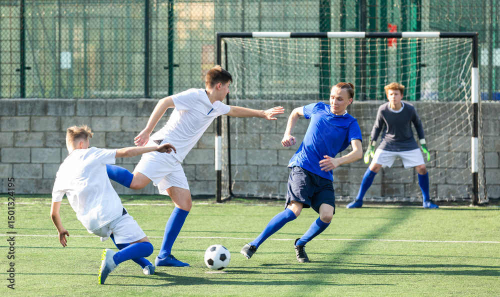 Fototapeta premium Teens playing soccer football match. Competition between two youth soccer teams. Football soccer tournament