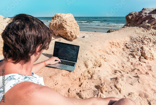freelancer with a laptop works on vacation