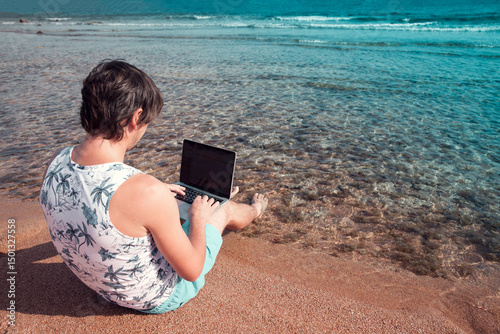 freelancer with a laptop works on a beach