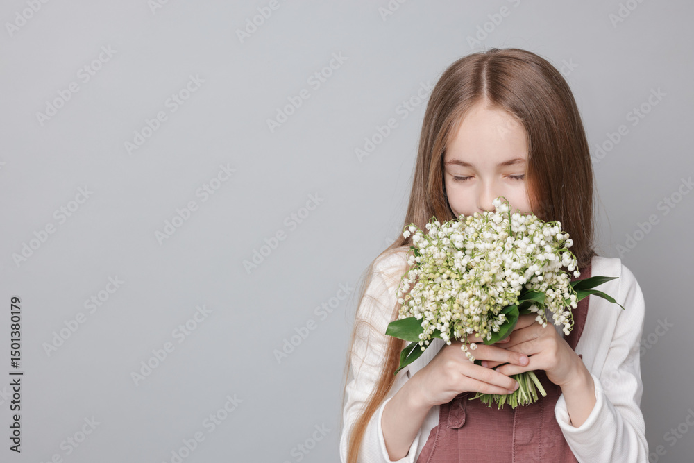 Girl with bouquet of beautiful lily-of-the-valley flowers on light grey background. Space for text Girl with bouquet of beautiful lily-of-the-valley flowers on light grey background. Space for text