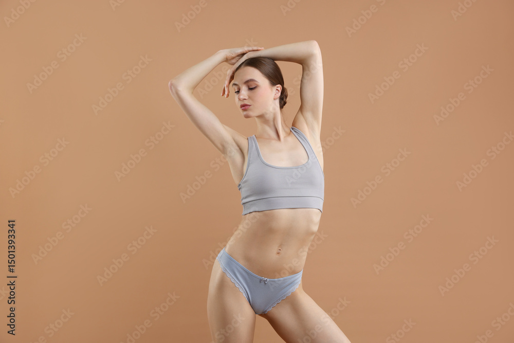 Obraz premium Woman wearing beautiful underwear on dark beige background