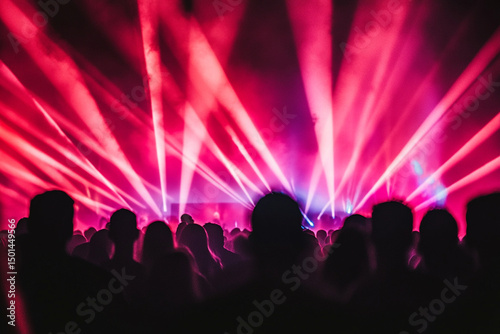 Silhouettes of people dancing in a vibrant nightclub with colorful lights