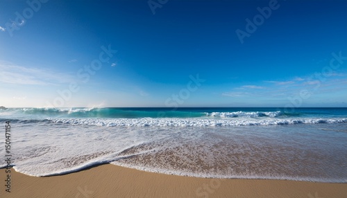 serene ocean view with gentle waves lapping against a sandy beach under a clear sky