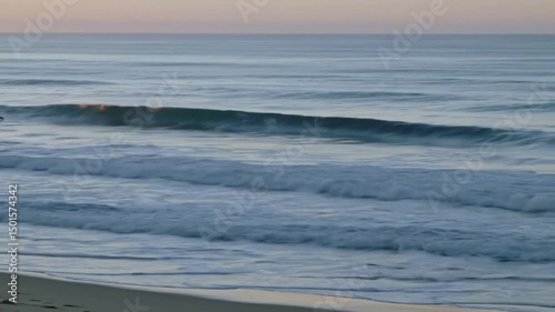 Ocean Waves Rolling Gently On Sandy Shore At Sunrise