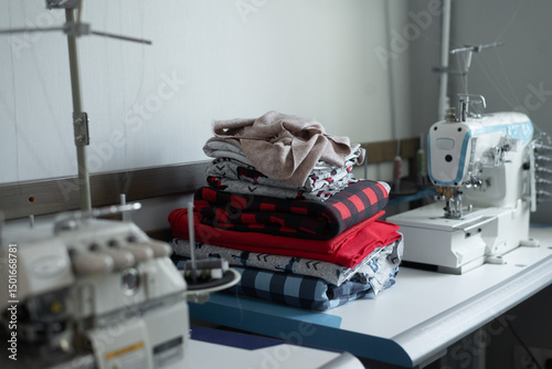 Sewing workshop with fabric stacks on a worktable