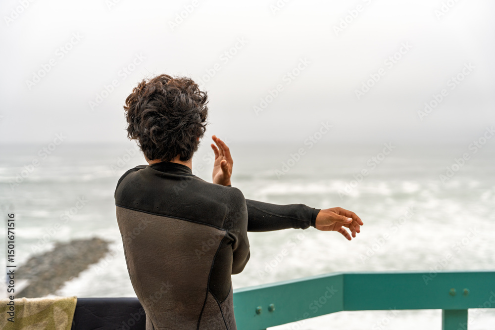 Ταπετσαρία Surfer wearing wetsuit on balcony of beach house getting ready for surfing