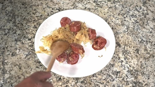 Enjoy a hearty meal featuring tender sausage slices served on a bed of flavorful sauerkraut