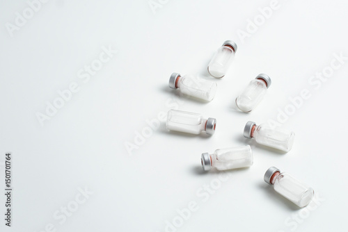 Flatlay of vaccine vial bottles with copy text space on white background. Flatlay of vaccine vials with white background, health medical concept.