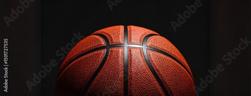 Close-up of a basketball under spotlight representing competition, sportsmanship and athletic preparation before a big game