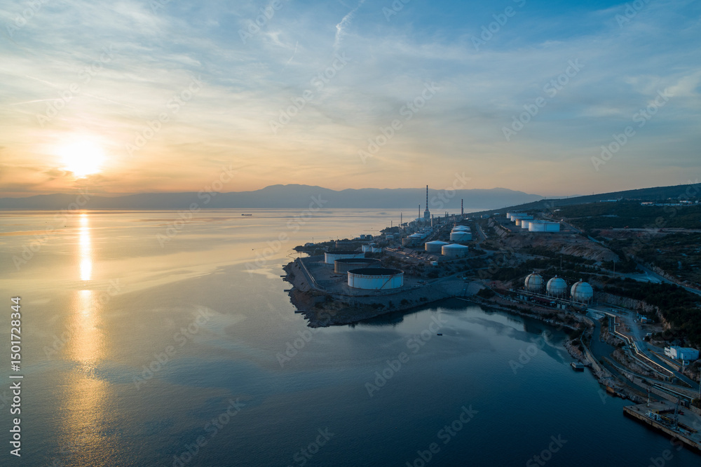 Aerial view of INA Oil Refinery at sunset with calm sea and industrial silhouette, Rijeka, Croatia. Aerial view of INA Oil Refinery at sunset with calm sea and industrial silhouette, Rijeka, Croatia.