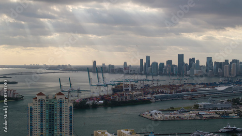 Aerial view of skyline with modern skyscrapers and PortMiami under cloudy skies, South Point, Florida, United States. photo