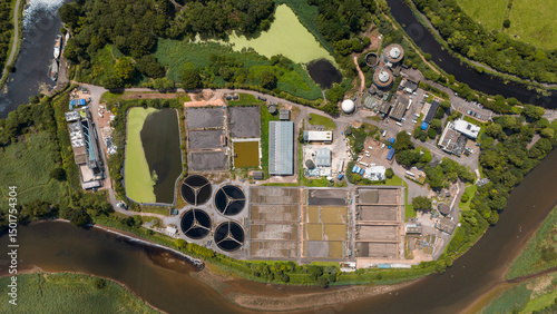 Aerial view of industrial water treatment plant with tanks and ponds beside a river, Exeter, England. photo