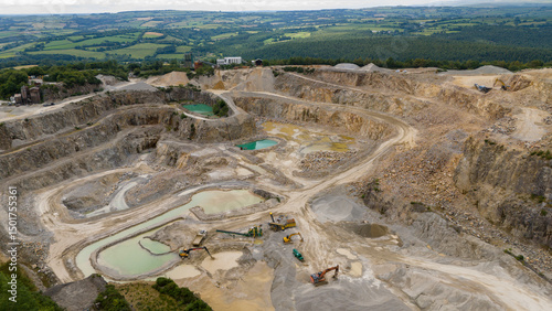 Aerial view of industrial quarry with heavy machinery and excavation pits, St Ann's Chapel, Gunnislake, England.