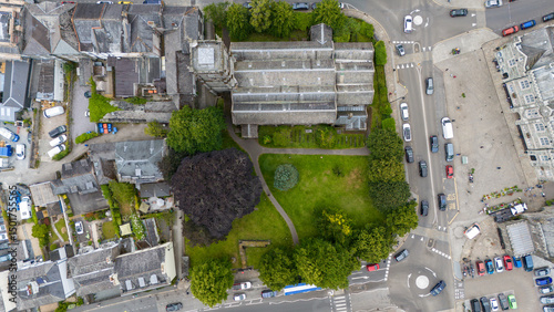 Aerial view of historic parish church and urban buildings surrounded by greenery and roads, Tavistock, United Kingdom. photo