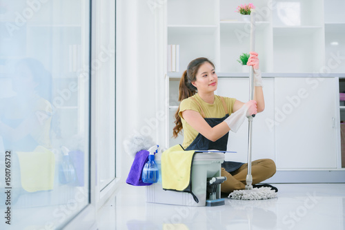 Fototapete .A depressed Asian wife in a yellow shirt is sitting on the floor with a bucket
