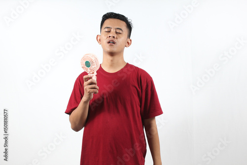 Asian man holding mini portable fan isolated on white background