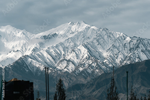 Bild auf Leinwand Majestic snow-covered peaks of the Himalayas rising through dramatic clouds, sho