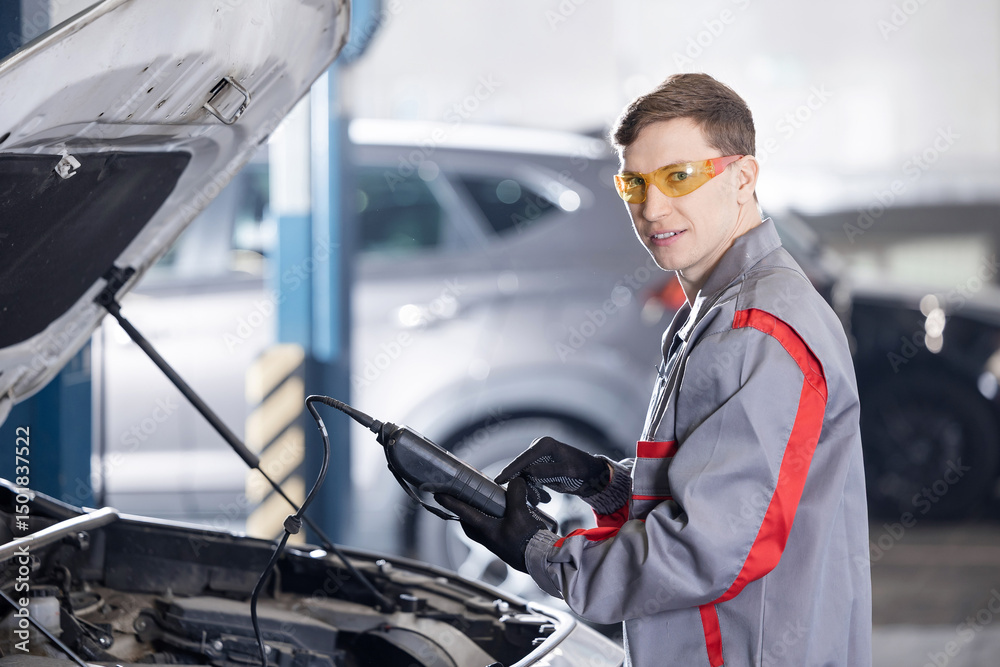 Obraz premium Man is measuring battery power of suv car by battery tester at garage service