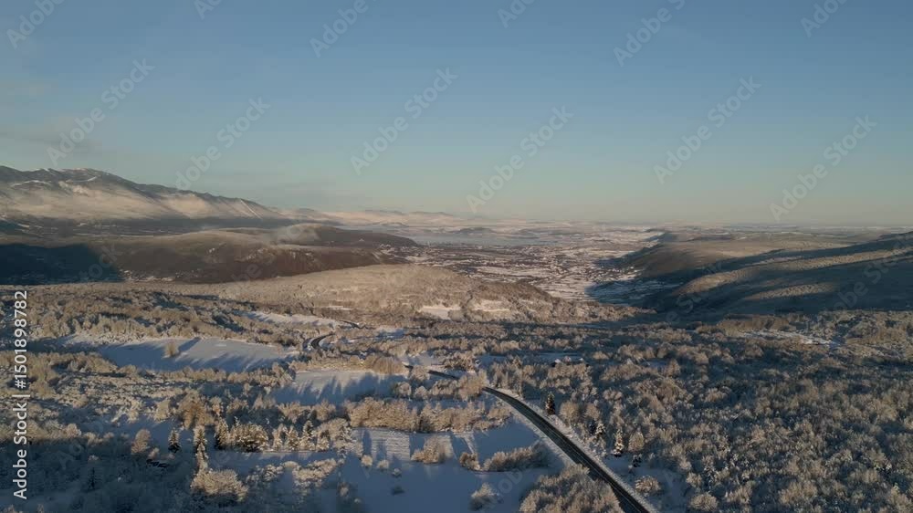 Toma aérea en la que el dron realiza un acercamiento visual hacia las montañas nevadas del Parque Nacional Una. Los árboles y el paisaje resaltan por su blancura invernal.